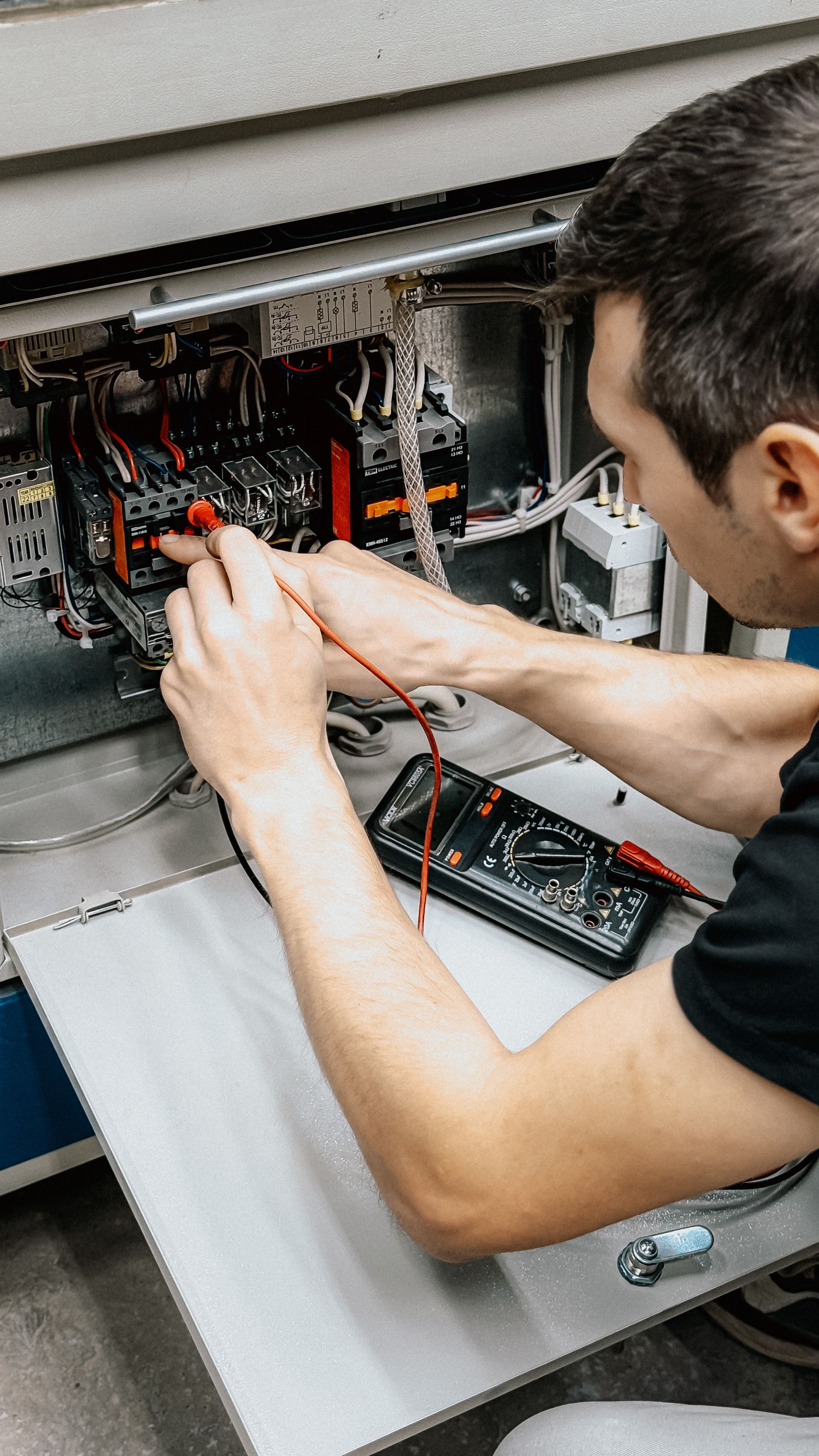 Electrician testing an industrial control panel