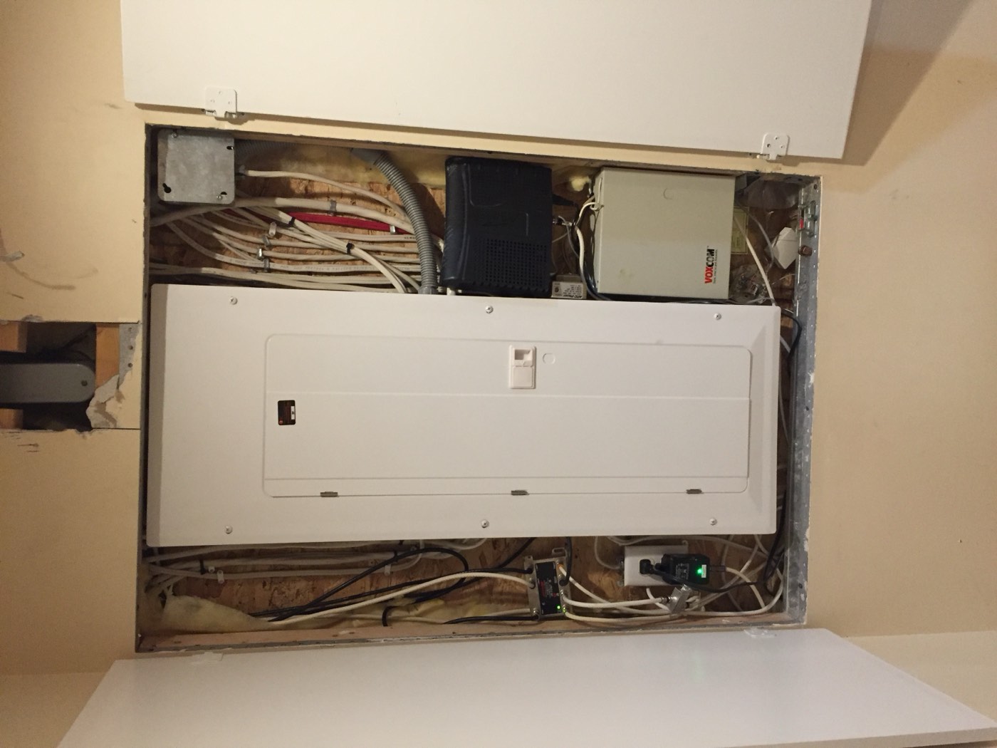 Finished residential electrical panel installed alongside low-voltage wiring