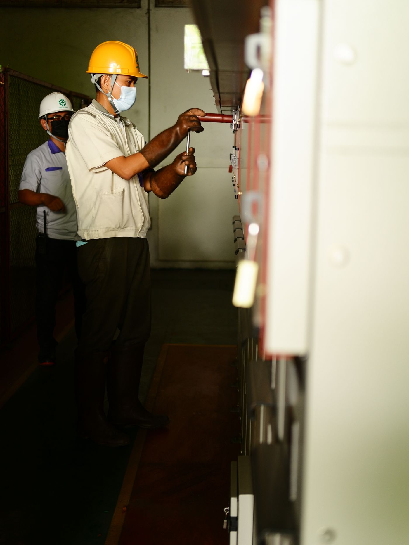Electrical technicians inspecting switchgear